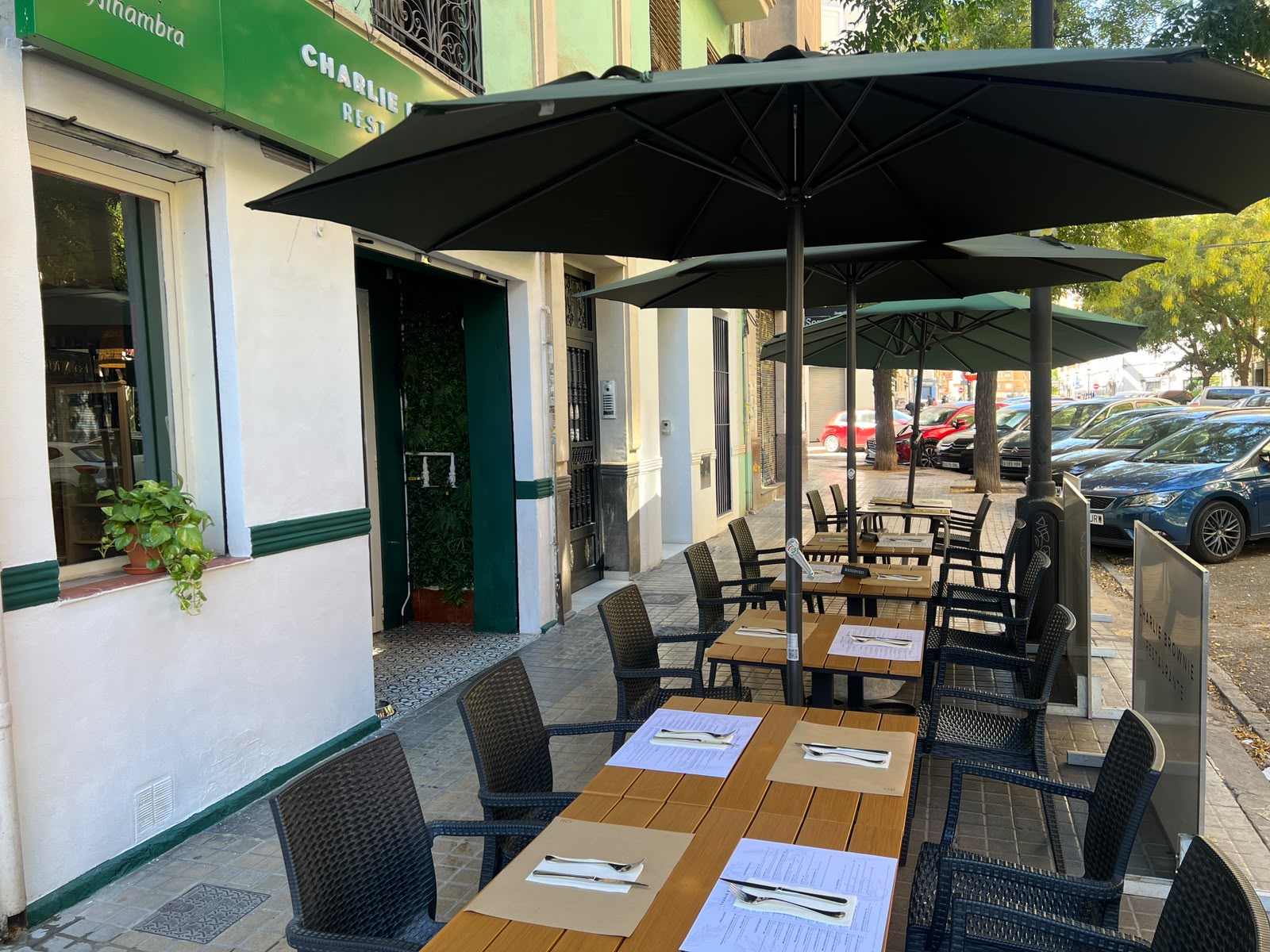 Terraza de Charlie Brownie con mesas y sombrillas en Extramurs Valencia